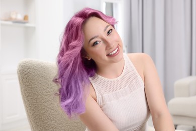 Trendy hairstyle. Young woman with colorful dyed hair at home