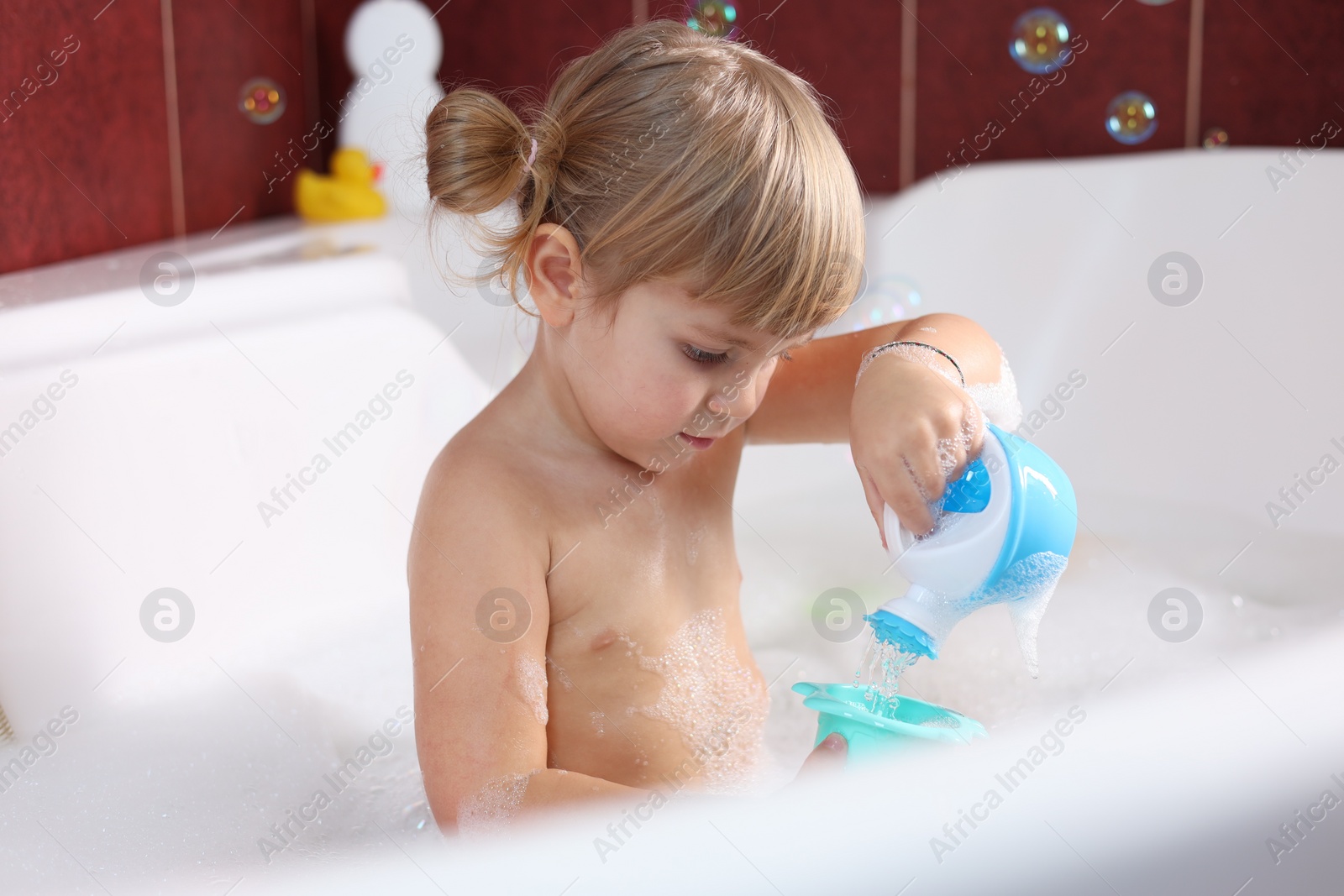 Photo of Little girl bathing in tub at home