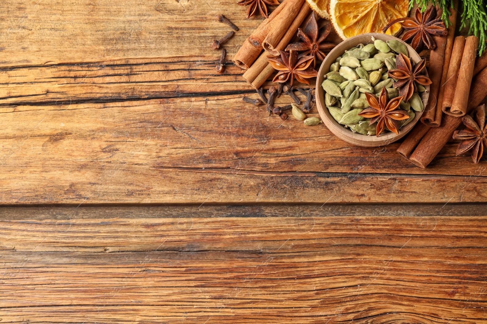Photo of Flat lay composition with mulled wine ingredients on wooden table. Space for text