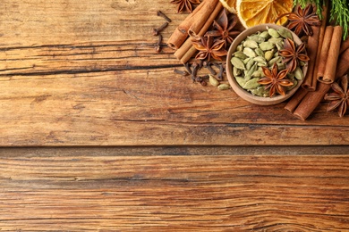 Photo of Flat lay composition with mulled wine ingredients on wooden table. Space for text