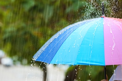 Photo of Person with bright umbrella under rain on street, closeup