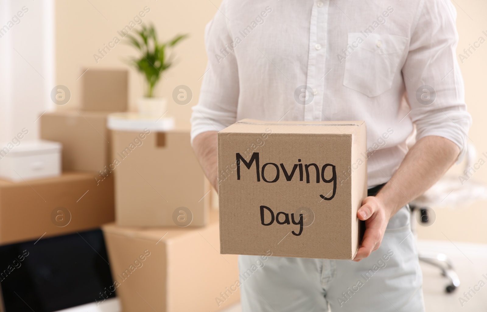 Photo of Man holding moving box in new office, closeup. Space for text