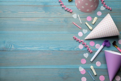 Flat lay composition with party items on light blue wooden table, space for text