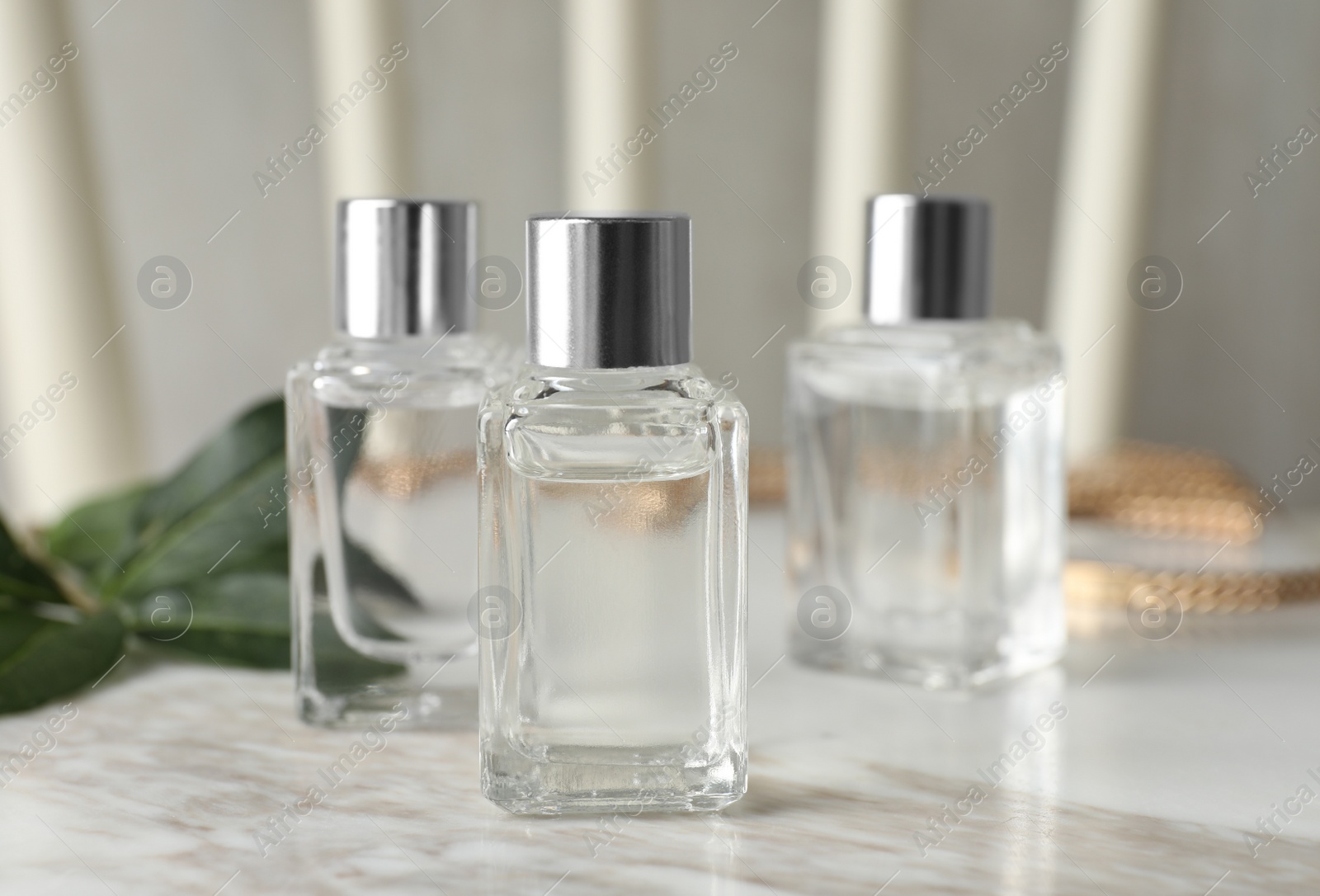 Photo of Bottles of essential oil on white marble table