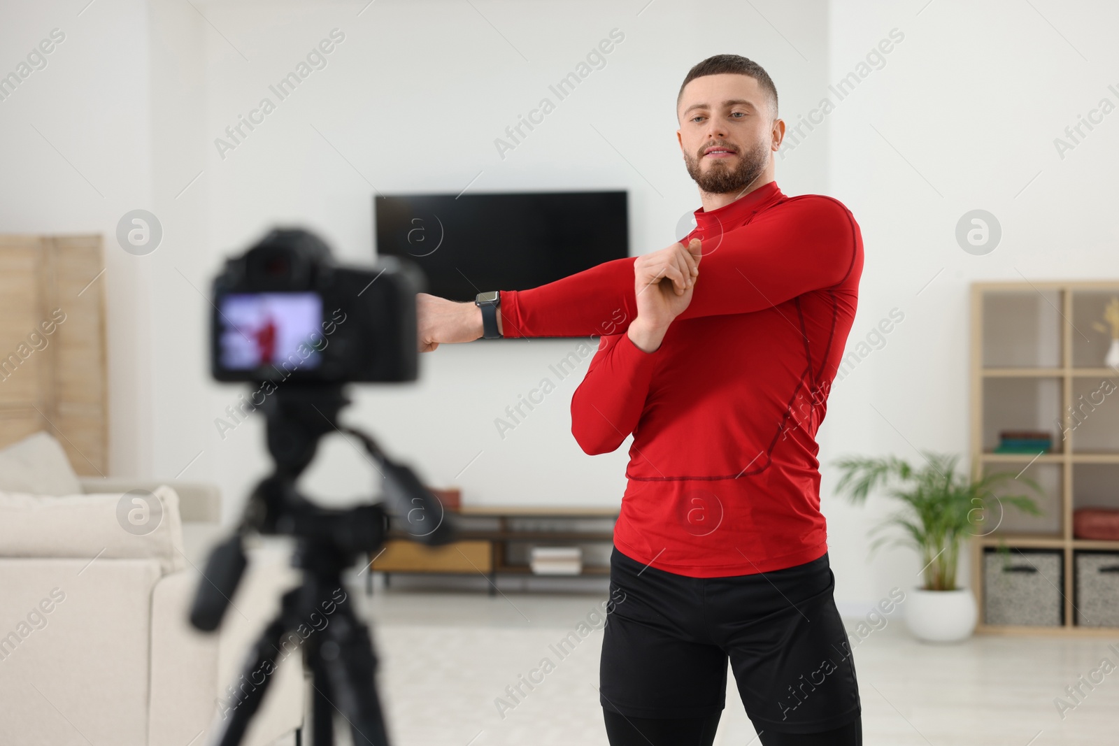 Photo of Trainer recording workout on camera at home