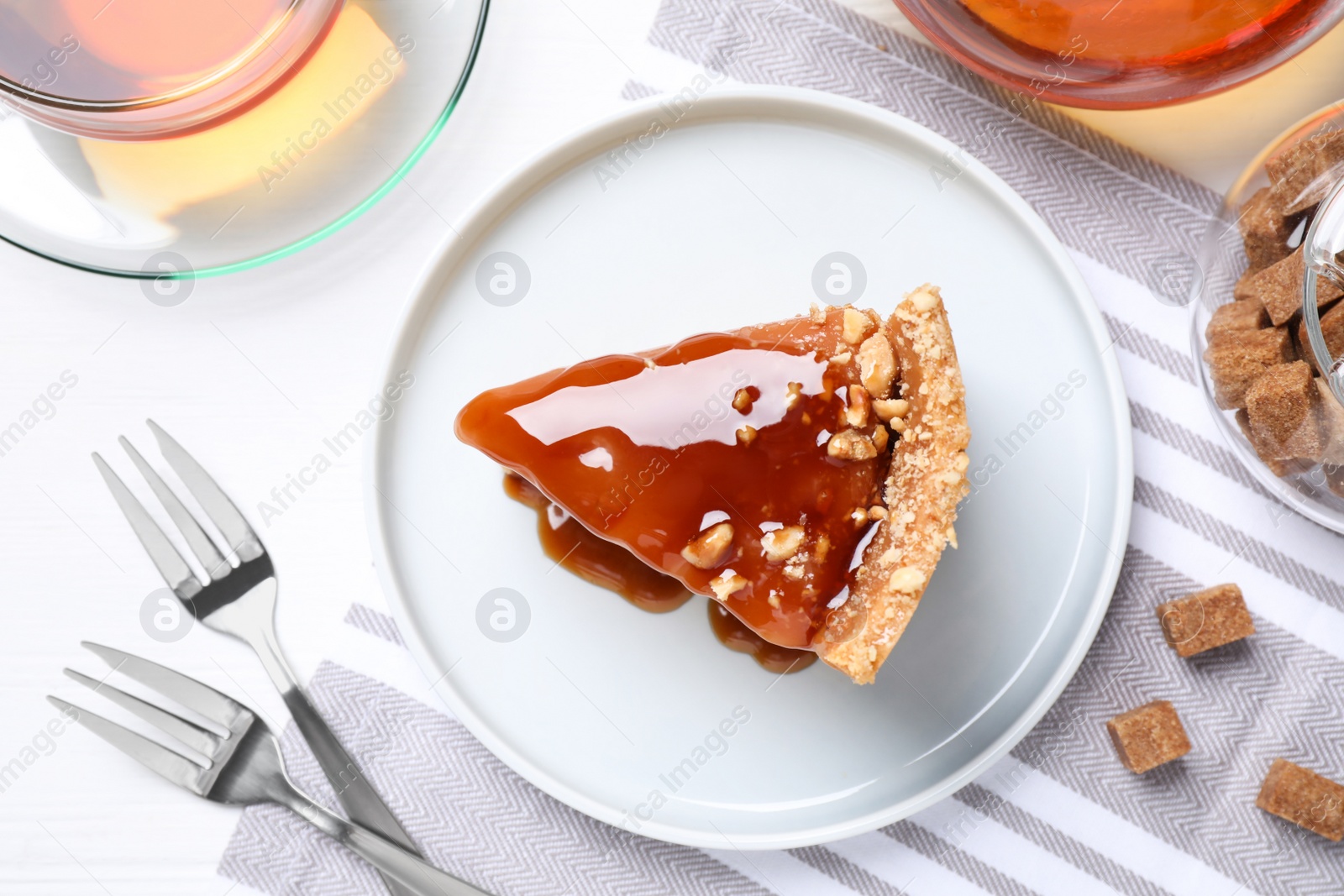 Photo of Slice of delicious cake with caramel sauce on table, flat lay