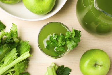 Photo of Glass of celery juice with fresh ingredients on white table, flat lay