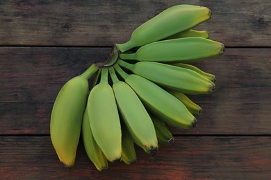 Photo of Bunch of delicious bananas on wooden table, top view