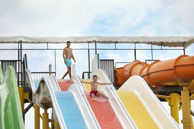 Photo of Cute little boy on slide in water park