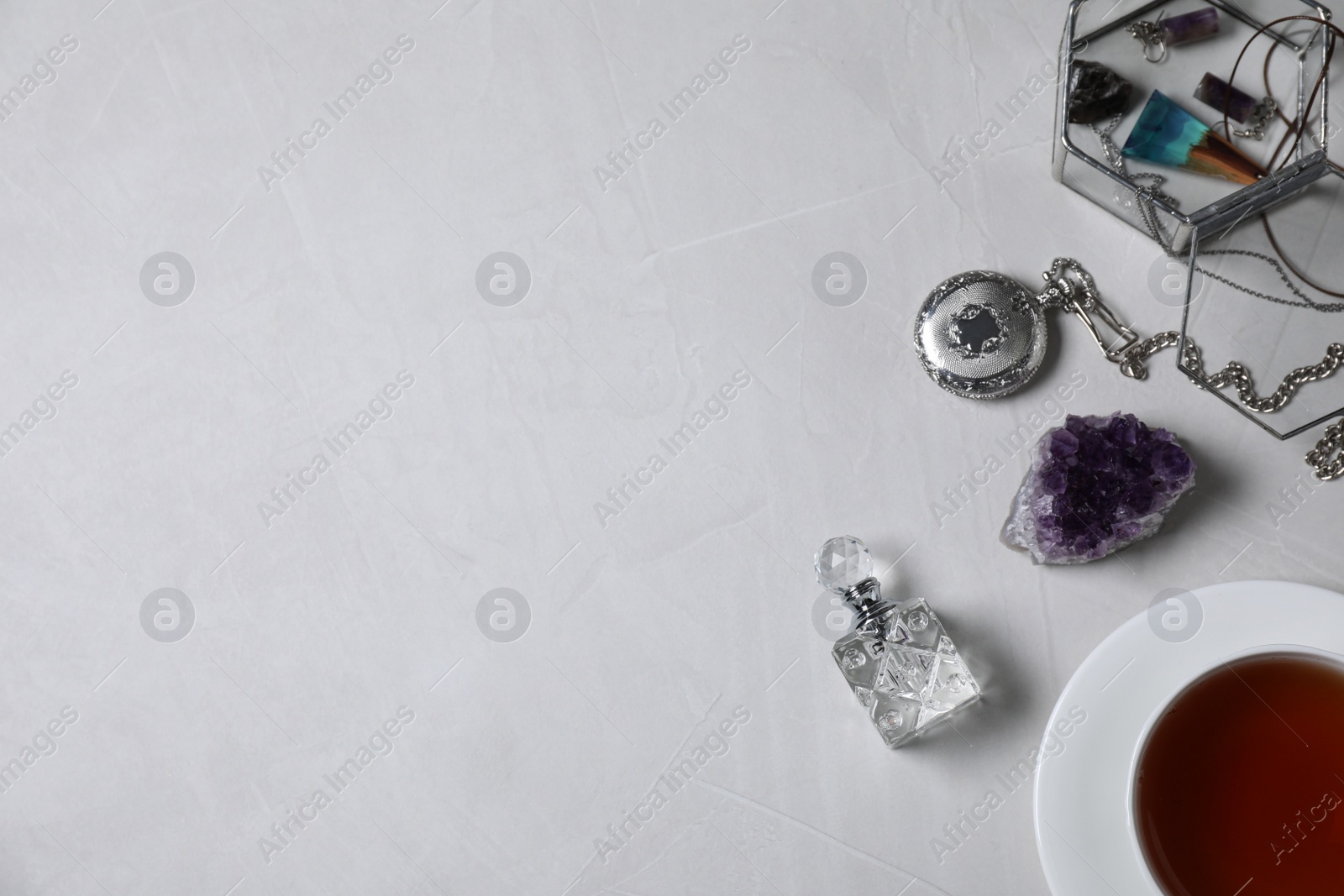 Photo of Flat lay composition with perfume and accessories on light grey table. Space for text