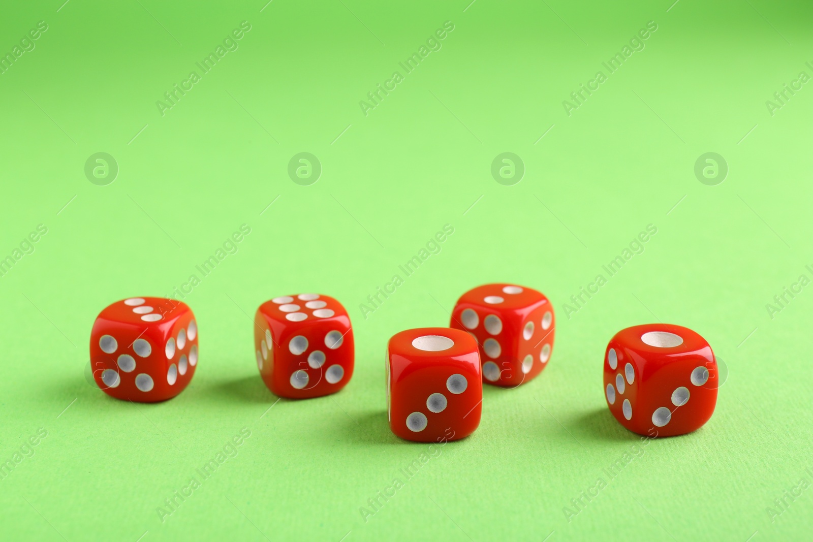 Photo of Many red game dices on green background