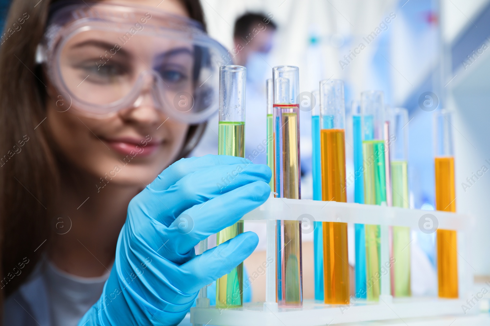 Photo of Scientist taking test tube from rack indoors. Laboratory analysis