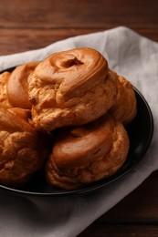 Photo of Many delicious fresh profiteroles on black plate