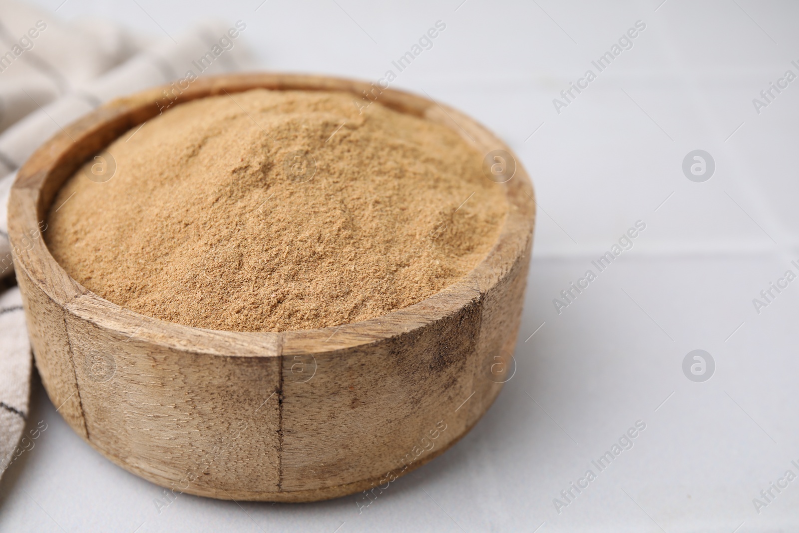 Photo of Dietary fiber. Psyllium husk powder in bowl on white table, closeup. Space for text