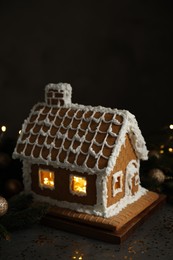 Beautiful gingerbread house decorated with icing on grey table