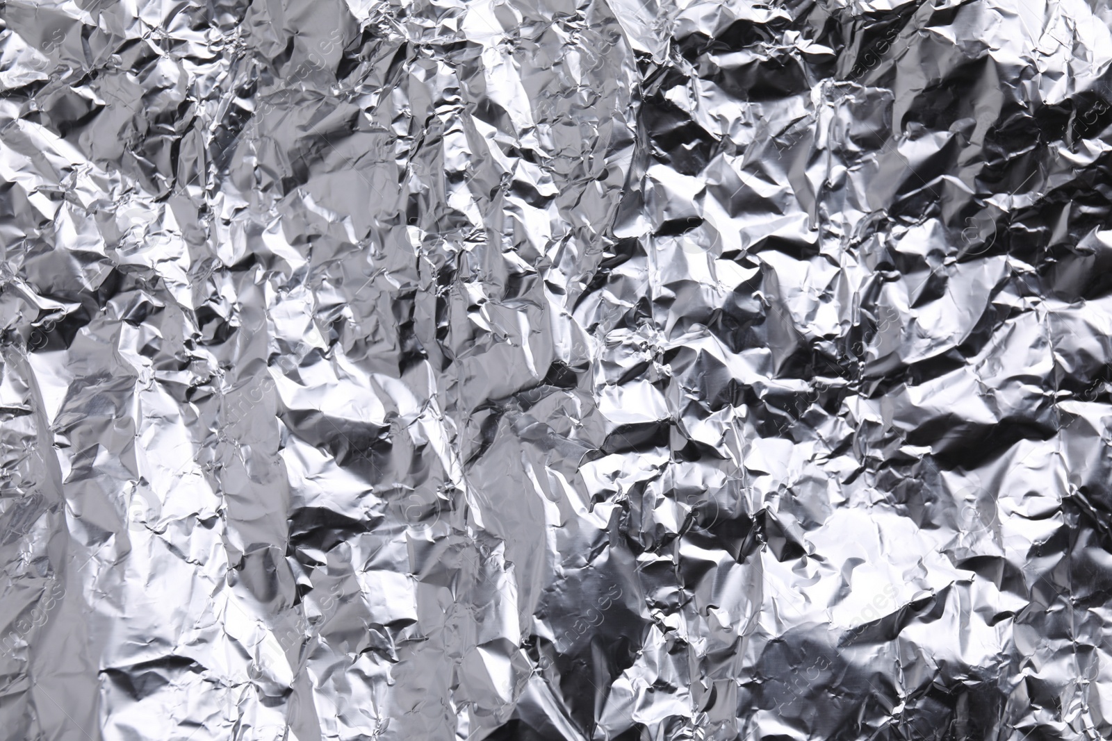 Photo of Crumpled silver foil as background, closeup view