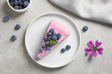 Plate with piece of tasty blueberry cake on light table, flat lay