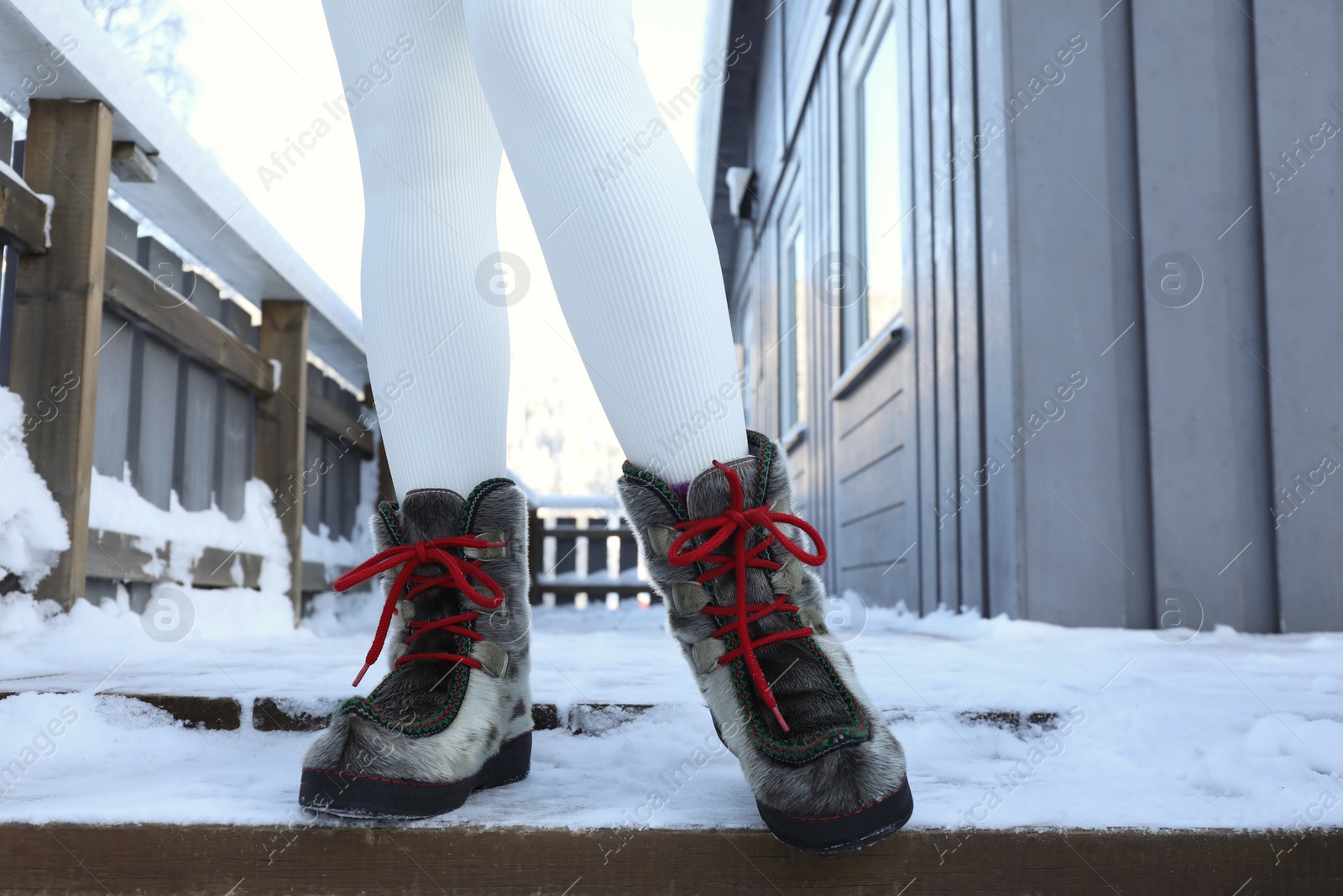 Photo of Woman in comfortable boots on snowy day outdoors, closeup. Winter vacation