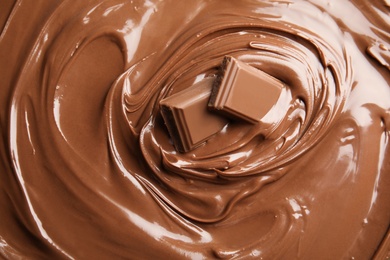 Photo of Sweet tasty chocolate cream with pieces as background, closeup