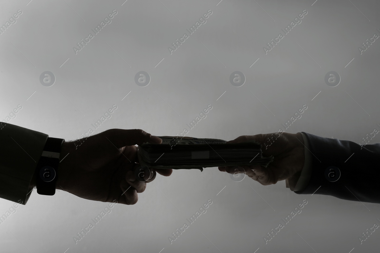 Photo of Silhouettes of woman giving bribe money to businessman on dark grey background, closeup