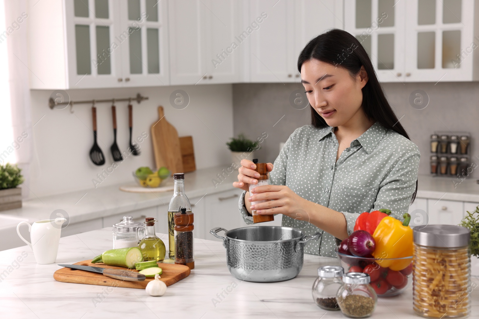 Photo of Beautiful woman cooking at countertop in kitchen