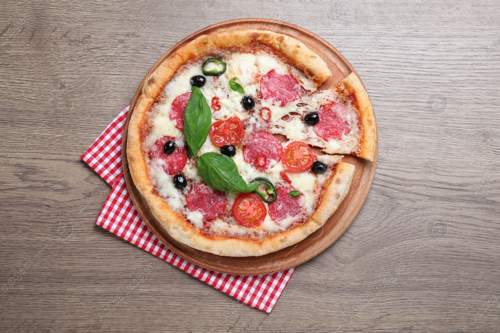 Photo of Delicious pizza Diablo and napkin on wooden background, top view