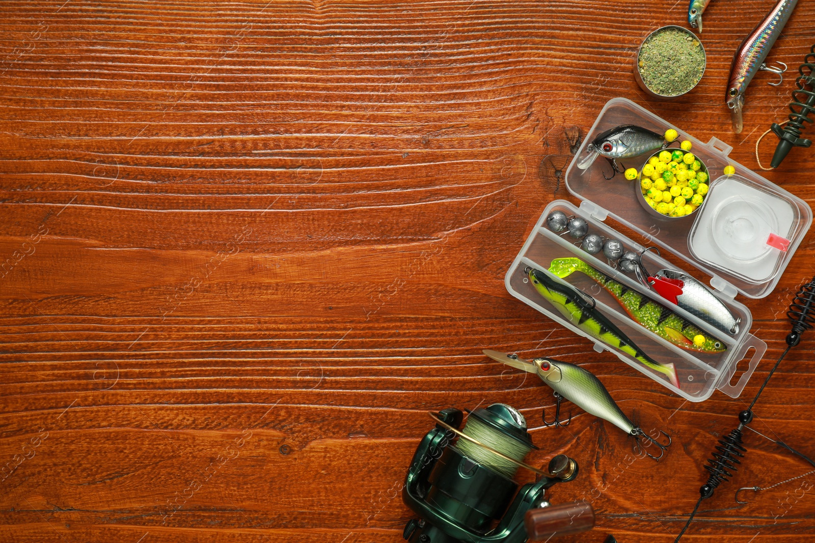 Photo of Fishing tackle on wooden table, flat lay. Space for text