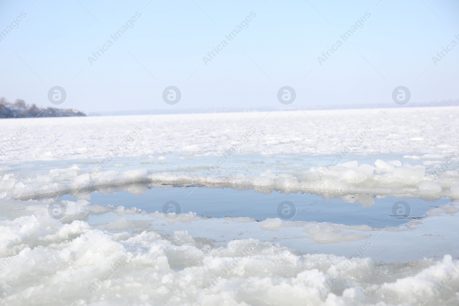 Photo of Ice hole in river on winter day. Baptism ritual