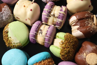 Photo of Delicious colorful macarons on black background, flat lay