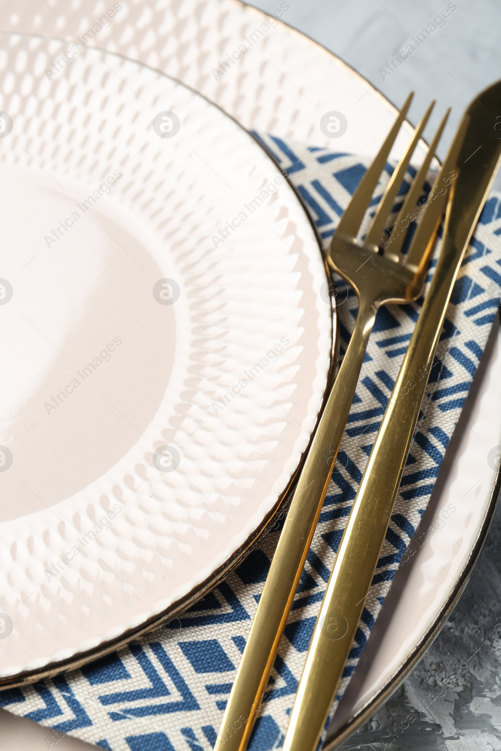 Photo of Clean plates, cutlery and napkin on table, closeup