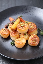 Photo of Delicious fried scallops on dark textured gray table, closeup