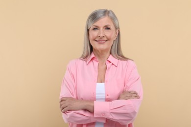 Portrait of beautiful senior woman on beige background