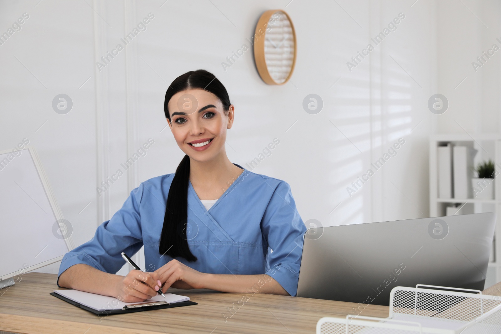 Photo of Receptionist with clipboard at countertop in hospital, space for text