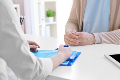 Photo of Female doctor consulting patient in clinic, closeup