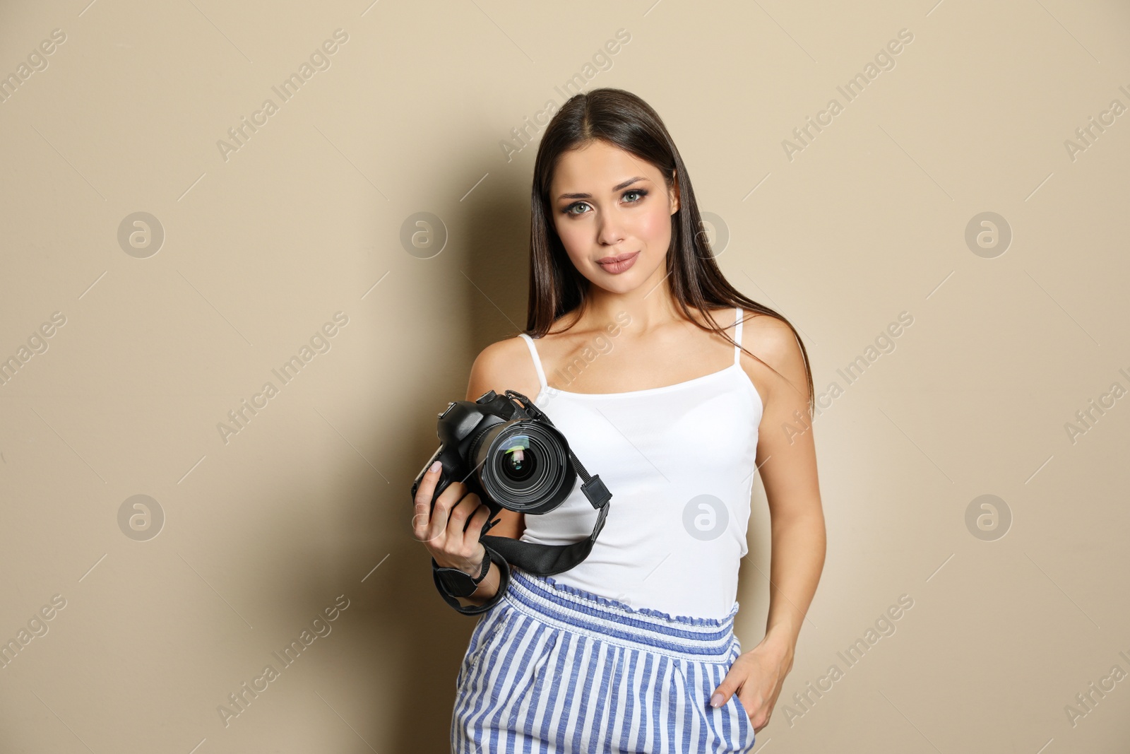 Photo of Professional photographer working on beige background in studio