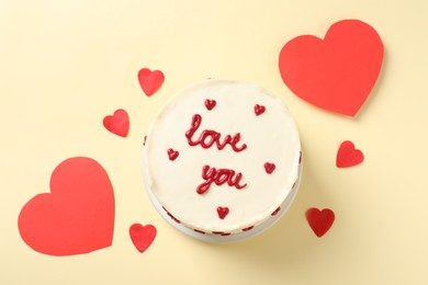 Bento cake with text Love You and paper hearts on beige table, top view. St. Valentine's day surprise