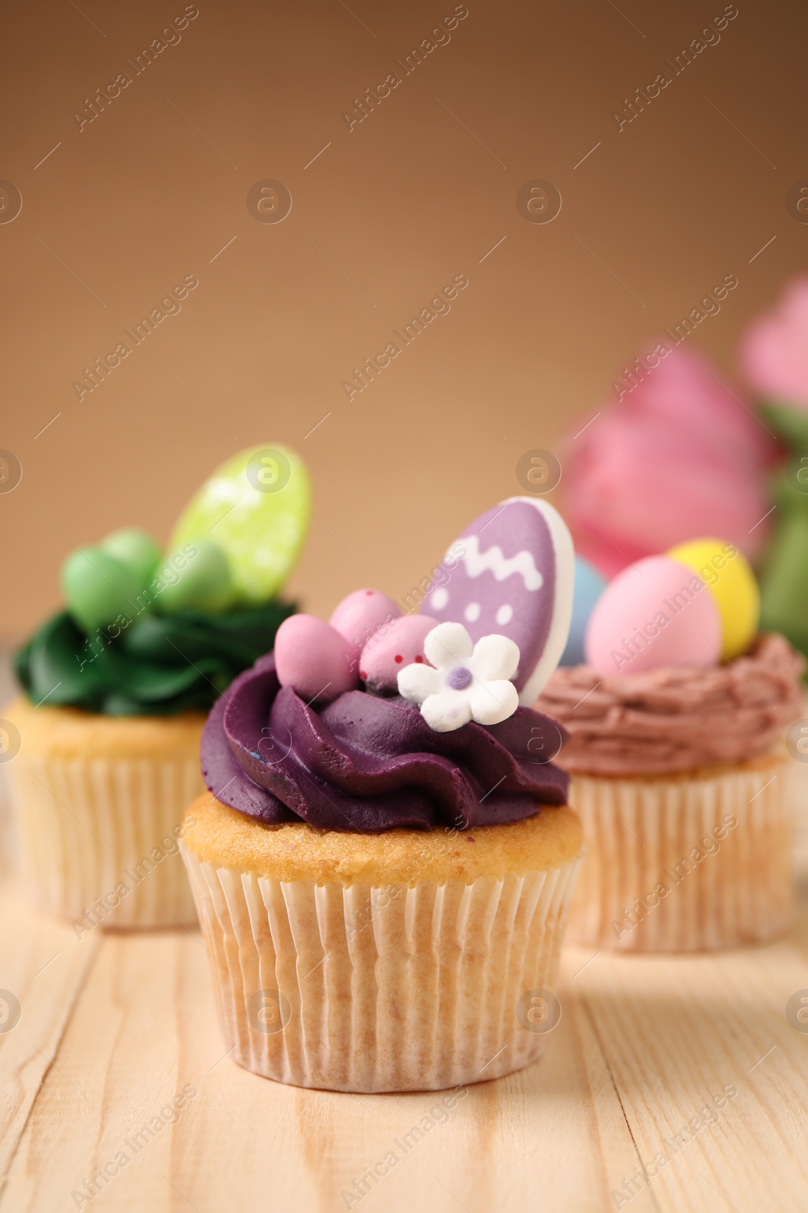 Photo of Tasty cupcakes with Easter decor on wooden table