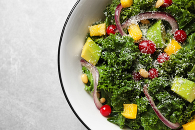 Photo of Tasty fresh kale salad on light grey table, top view