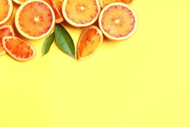 Fresh bloody oranges on color background, flat lay with space for text. Citrus fruits