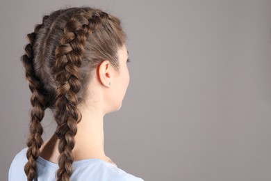 Photo of Woman with braided hair on grey background. Space for text