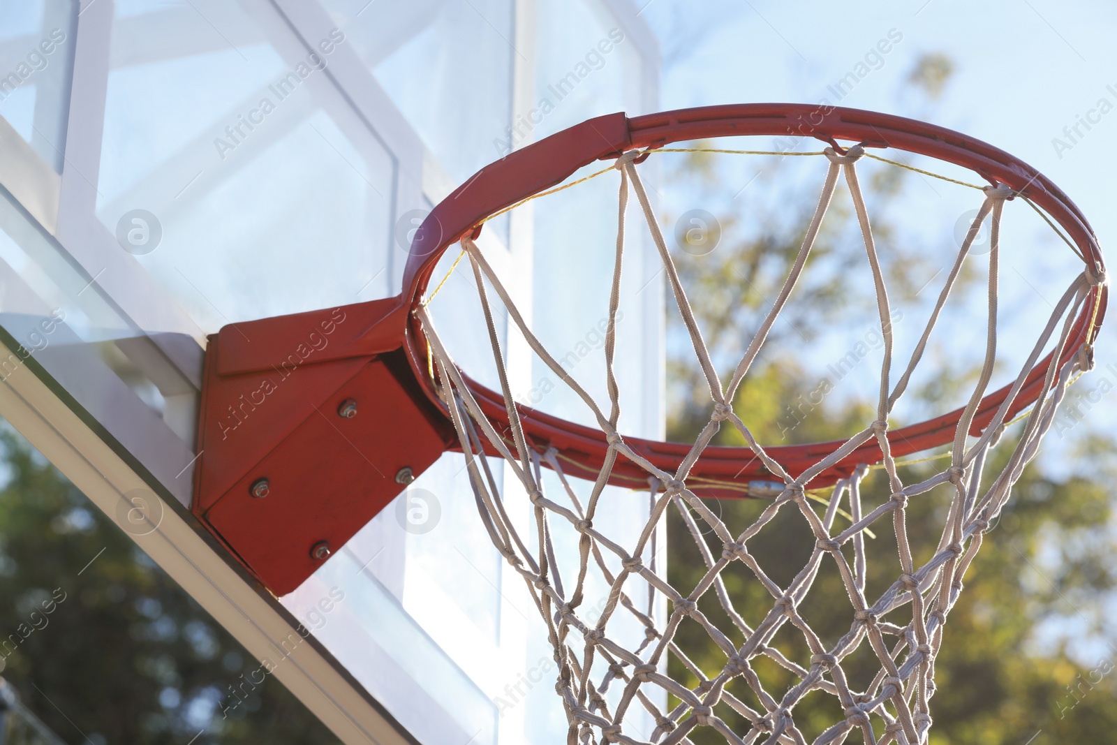 Photo of Basketball hoop with net outdoors on sunny day