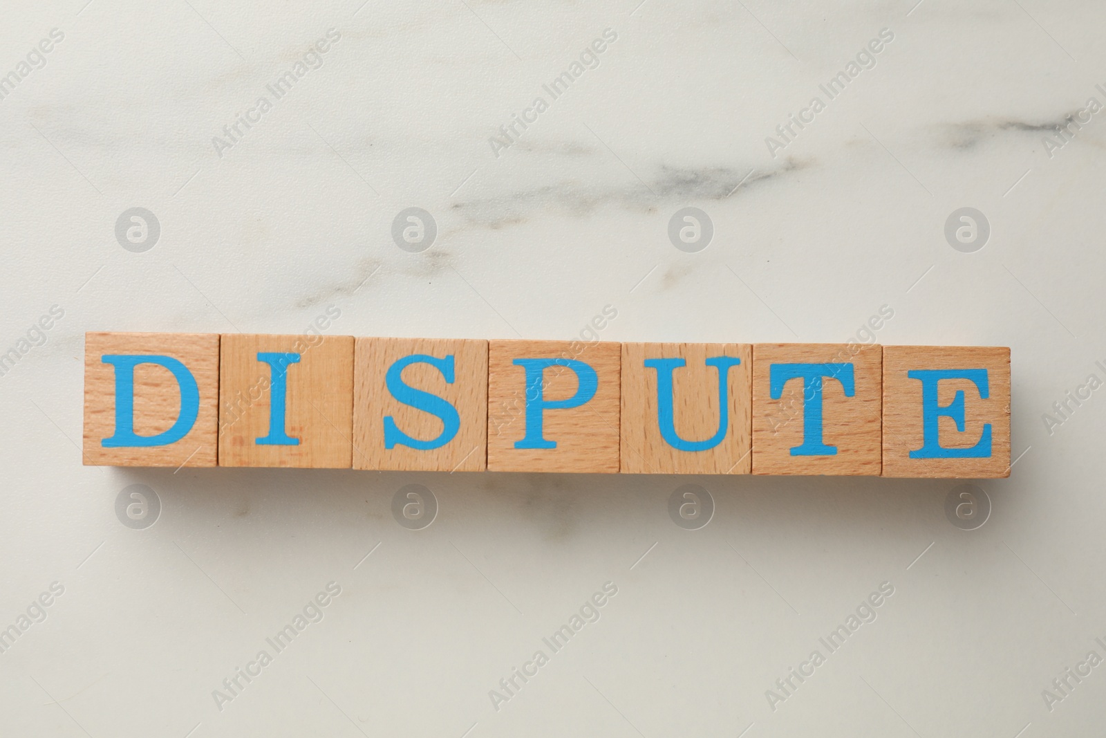 Photo of Cubes with word Dispute on white marble table, top view