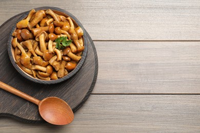 Delicious marinated mushrooms on wooden table, top view. Space for text