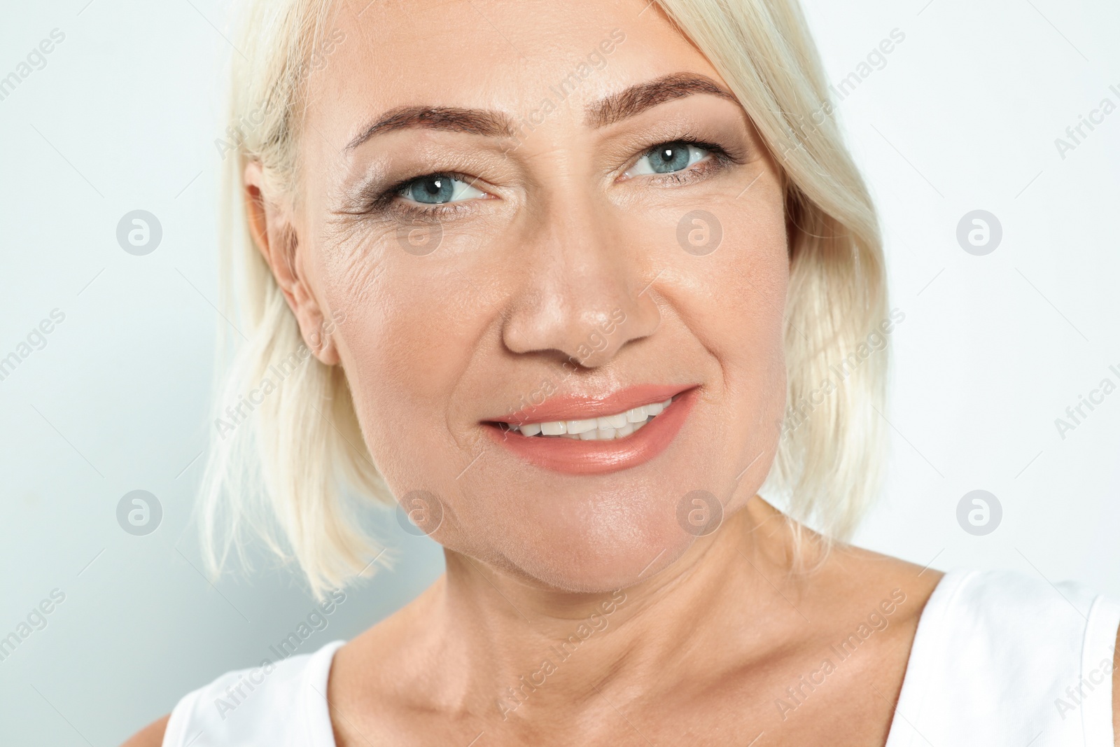 Photo of Portrait of mature woman with beautiful face on grey background