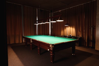 Photo of Empty green billiard table in club. Pool Game