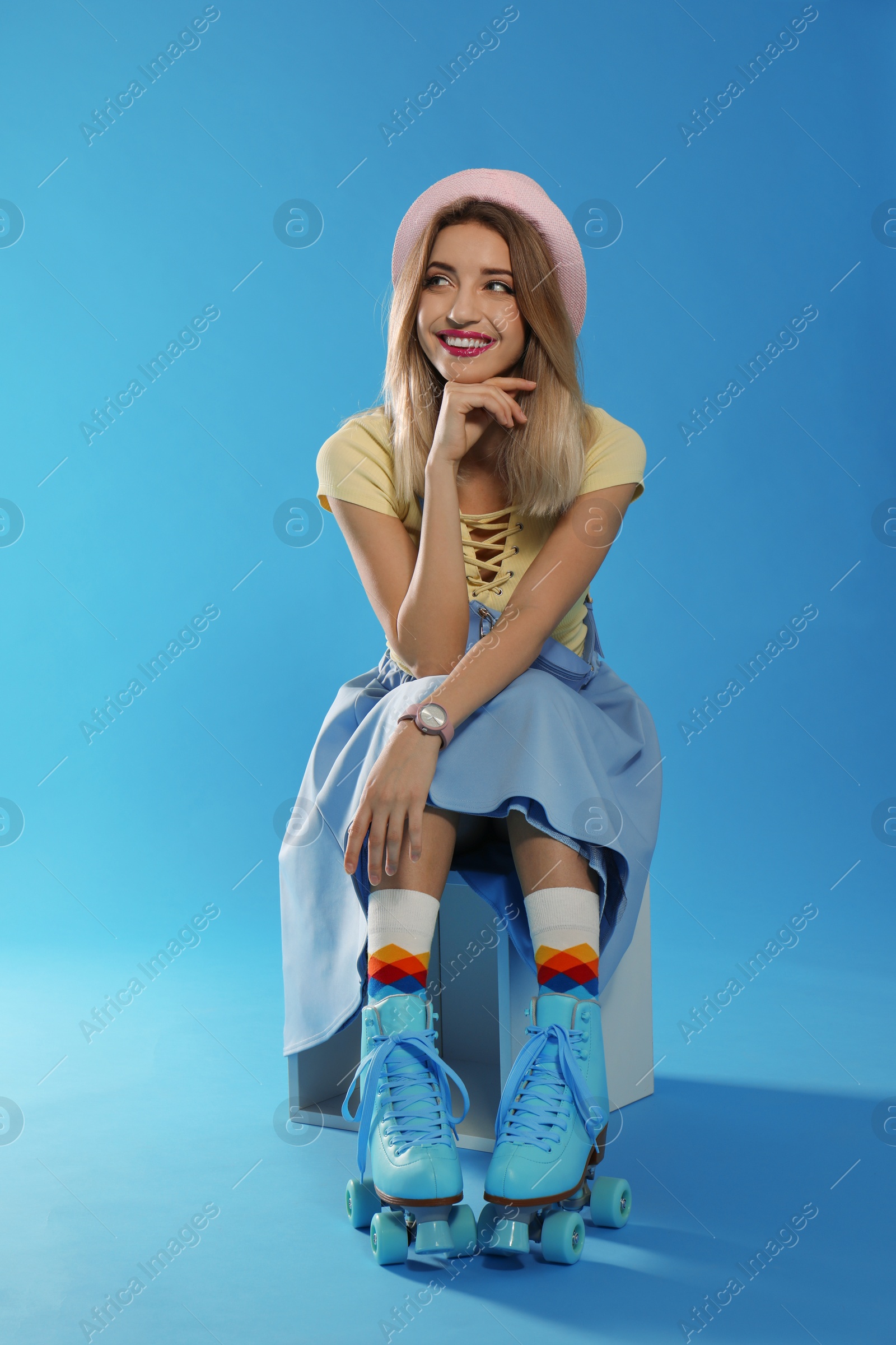 Photo of Young woman with retro roller skates on color background