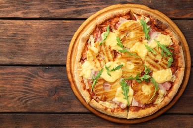 Photo of Delicious pineapple pizza with arugula on wooden table, top view. Space for text