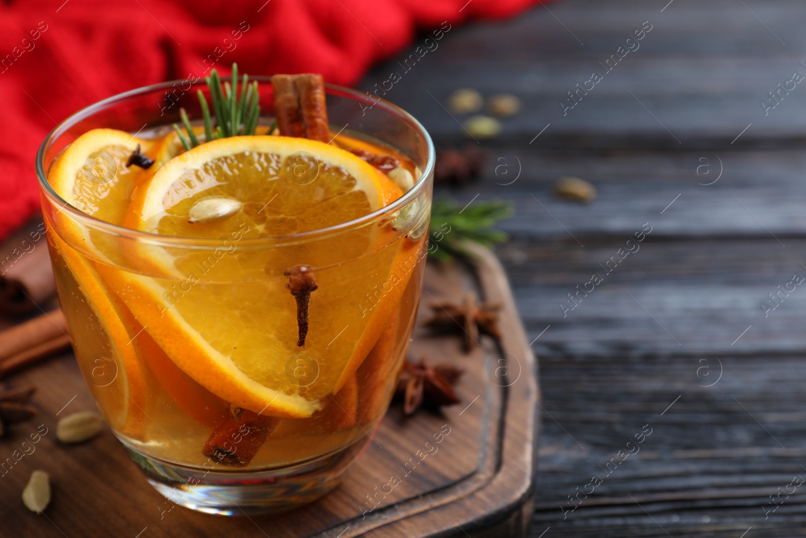 Photo of Aromatic mulled wine on wooden board. Space for text