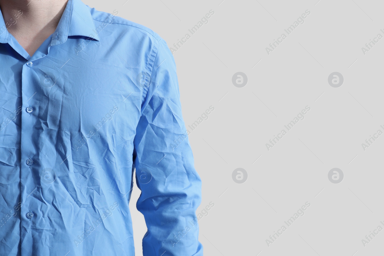 Photo of Man wearing creased shirt on light background, closeup. Space for text