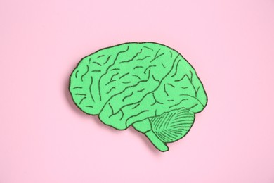 Photo of Paper cutout of human brain on pink background, top view